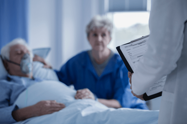 elderly man lying in a hospital bed