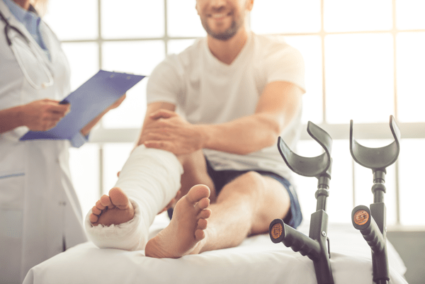 man in a leg cast at a doctor's office