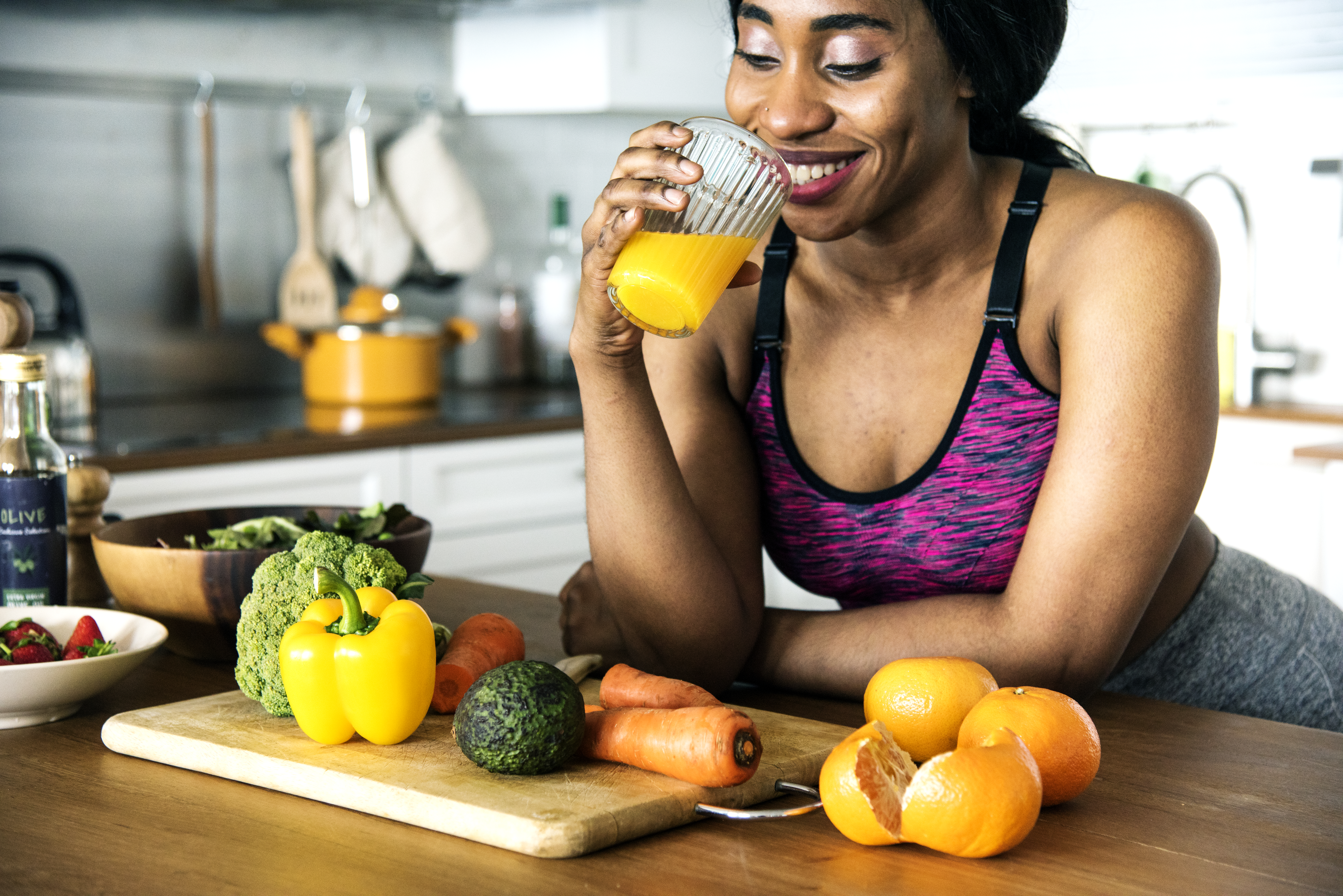 Woman drinking juice and looking at vegetables