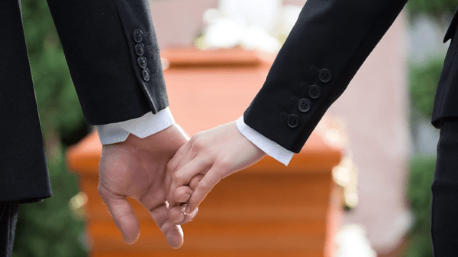 Couple holding hands at a funeral