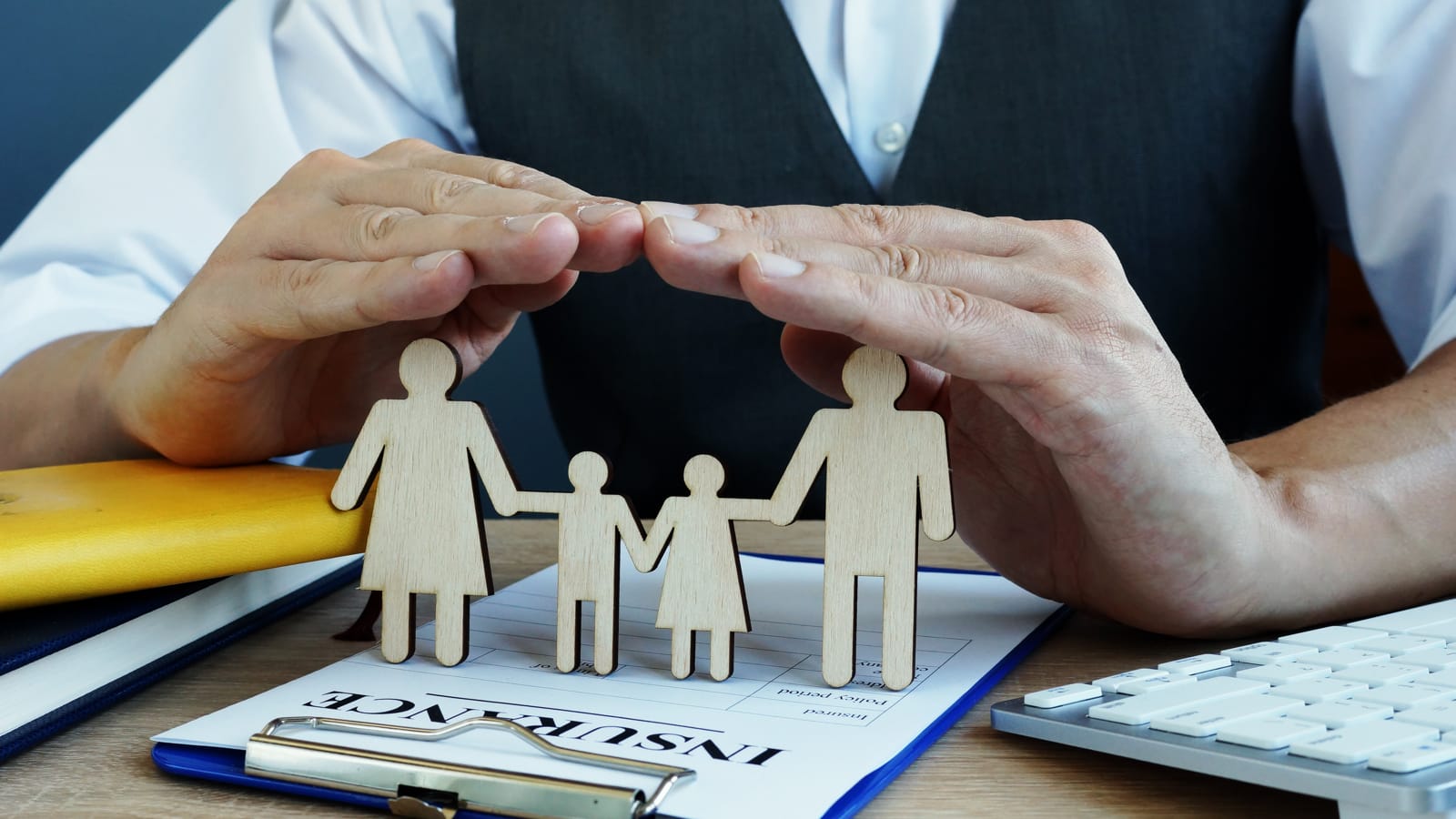 Hands protecting a cardboard family