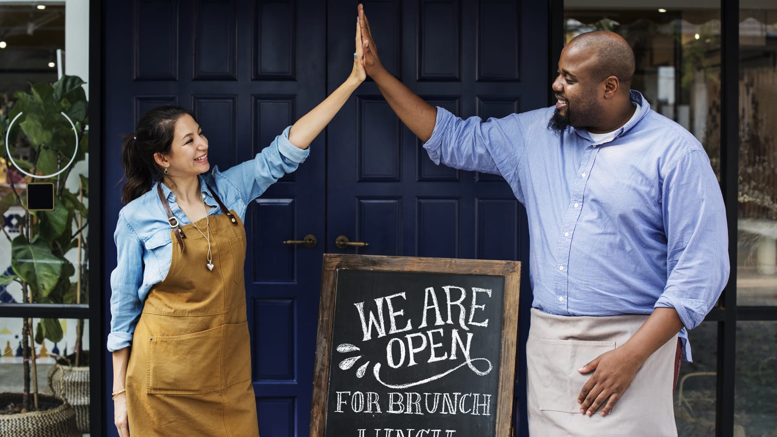 Self-employed restaurant owners high-fiving