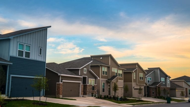 Row of homes beneath a colorful sky