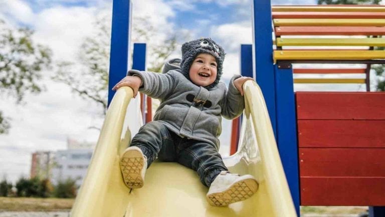 Kid playing on a school playground slide