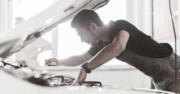 guy_looking_under_the_hood_of_a_car_575x300