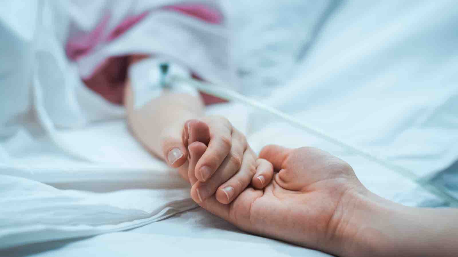 Hospital patient holding hands with visitor