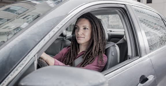 lady_sitting_in_a_car_driver_seat_575x300