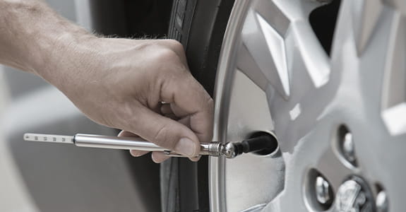 someone_checking_tire_pressure_575x300