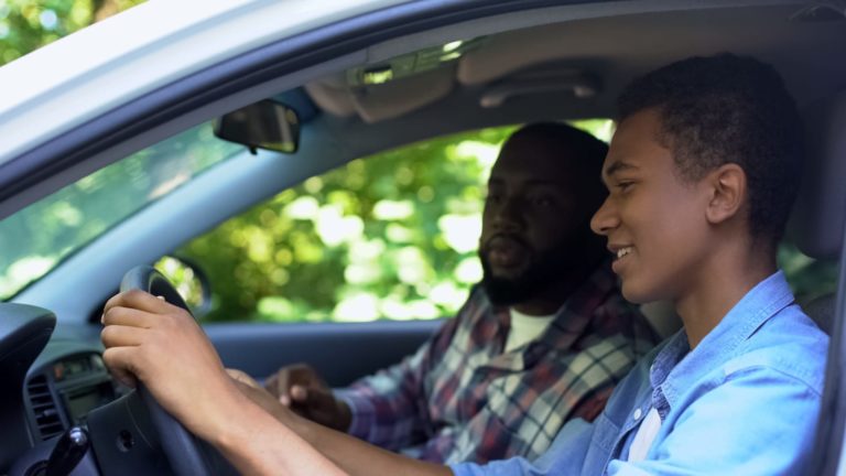 Father teaching teenage son to drive