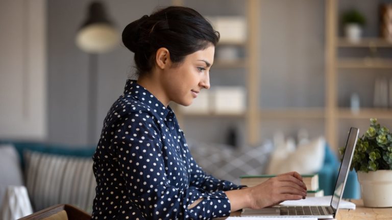 Woman on Laptop Researching Business Insurance for her LLC