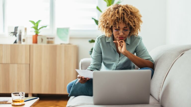 Young African-American woman reading on her laptop.