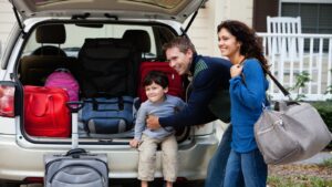 Young family packing up car for trip.