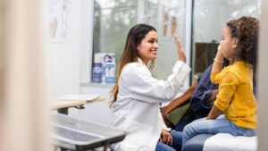 Young female doctor high-fiving child patient.