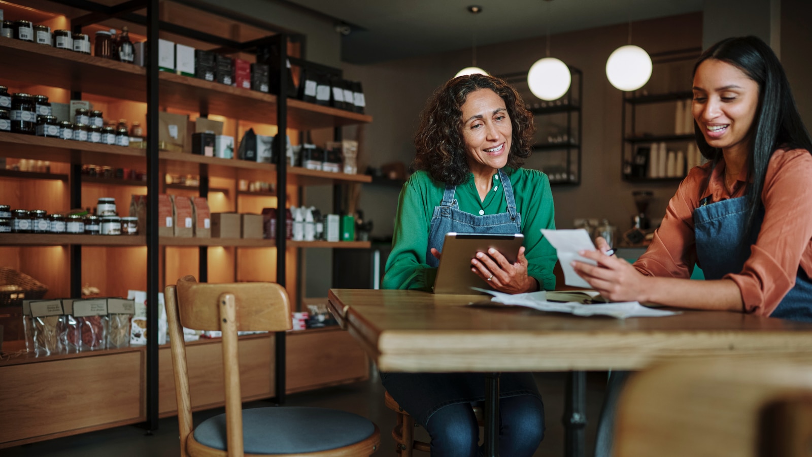 Two female business owners having discussion in shop.