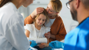 Mother and little girl with broken arm in hospital