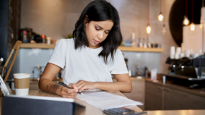 A woman in cafe signing papers