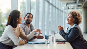 Happy diverse couple talking to an agent