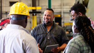 Multiracial group in factory having a conversation.