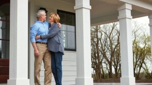 Older couple embracing on front porch