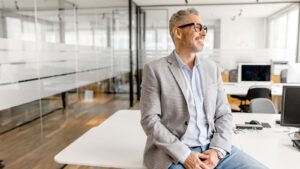 male business owner leaning on desk